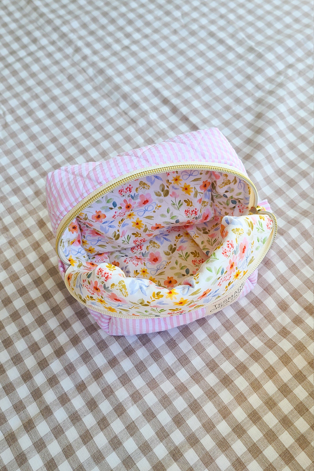 Small fabric pouch with floral interior on a checkered fabric background