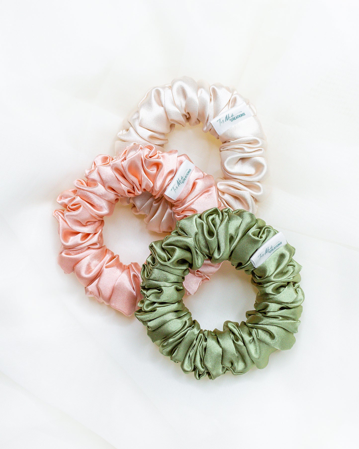 Mini Size Silk Satin Scrunchies in the color champagne, peach, and sage.